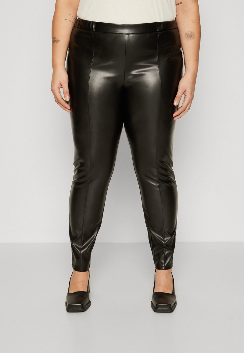 Black faux leather leggings with a slim fit, featuring a smooth texture, waistband, and tapered legs. Worn with black square-toed heels.