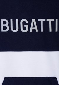Felpa blu navy e bianca con grande scritta "BUGATTI" in argento. Realizzata in morbido cotone, presenta una tasca a marsupio.