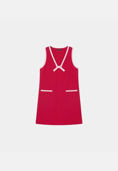 Robe rouge sans manches avec un décolleté en V profond, bordure rose, nœud au niveau de l'encolure et deux poches horizontales à l'avant avec bordure rose.