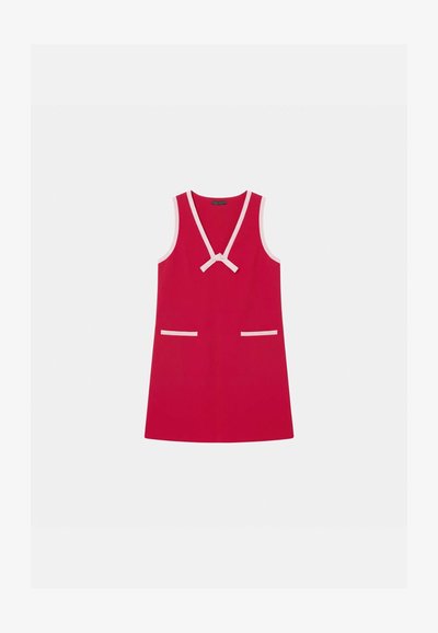 Robe rouge sans manches avec un décolleté en V profond, bordure rose, nœud au niveau de l'encolure et deux poches horizontales à l'avant avec bordure rose.