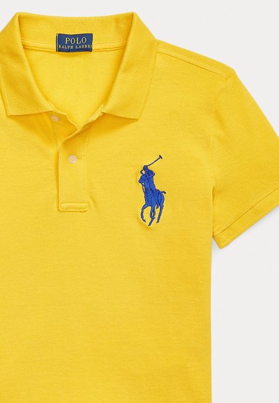 Κίτρινο πόλο μπλουζάκι από υφή ύφασμα με μπλε κεντητό λογότυπο παίκτη πόλο στο αριστερό στήθος, με δύο κουμπιά στη λαιμόκοψη.