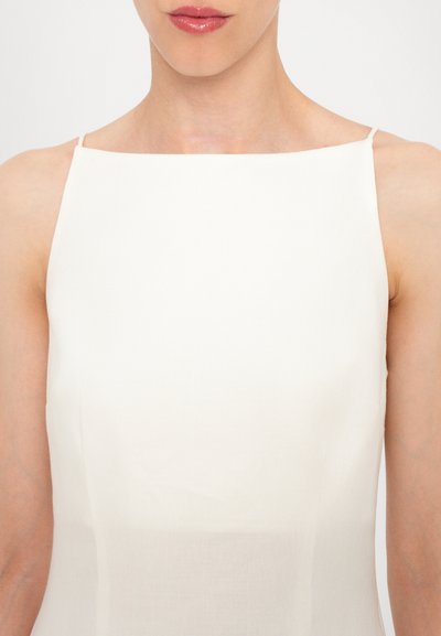 Hvid udenærmet kjole med kvadratisk halsudskæring. Lavet af glat stof, med en let tekstur og minimalistisk design.