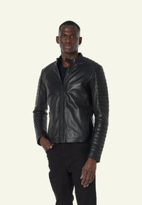 Zwarte leren jas met een hoge kraag, slank ontwerp, geribde schouderaccenten en een rits aan de voorkant. Geschikt voor casual draag.