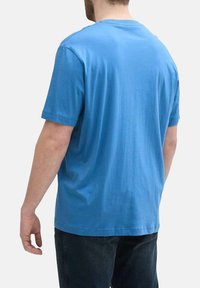 T-shirt en coton à manches courtes de couleur bleu vif, avec un col rond et une coupe décontractée, vu de l'arrière avec une texture lisse.