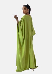 Lång grön kaftan gjord av lättviktig tyg, med vida ärmar, en lös passform, och en hög halsringning med en liten öppning bak.