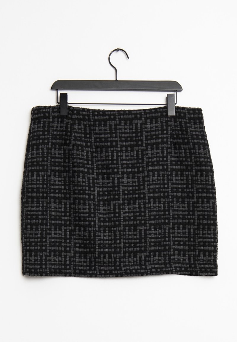 Falda con estampado en negro y gris, de tela texturizada, con forma recta y cintura, colgando de un perchero de plástico negro.