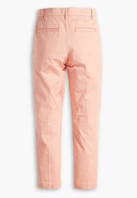 Persikofärgade bomullsbukser med rak bendesign, bakfickor och subtila frontveck, med en mjuk textur och ren finish.