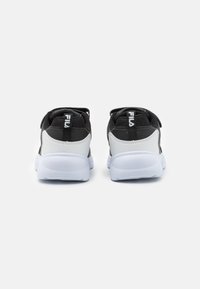 Chaussures de sport noir et blanc avec tige en maille, col rembourré et sangles ajustables. Dotées d'une semelle en caoutchouc et d'un logo Fila à l'arrière.