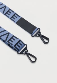 Μπλε υφασμάτινος ιμάντας με μαύρο πλαστικό γάντζο περιστροφής και στις δύο άκρες και μαύρο ορθογώνιο μπαλώμα ραμμένο κοντά σε έναν από τους γάντζους.