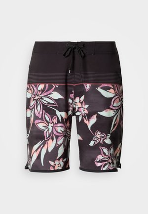 Bañadores de hombre tipo boardshorts con un fondo oscuro y patrones florales multicolores. Cintura negra con cordón y aperturas laterales para facilitar su uso.