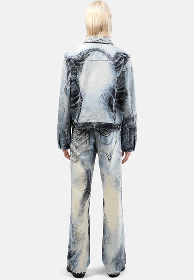 Bleu vaale denim-takki ja leveälahkeiset housut tummilla yksityiskohdilla. Kulutettu pinta, tarkka ompelu ja suuret taka-taskut housuissa.