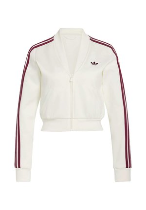 Witte cropped jack met ritssluiting, gemaakt van zachte stof met bordeauxrode accentstrepen op de mouwen en een geborduurd logo op de linkerborst. Voorzien van twee zakken.