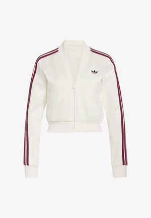 Afkortet hvid lynlåstrøje i blødt stof med bordeaux-accentstriber på ærmerne og broderet logo på venstre bryst. Har to lommer.