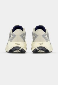 Zapatillas deportivas gris claro con tela texturizada, diseño estampado y suelas de goma negras. Cuentan con talón acolchado y entresuela de espuma energética.