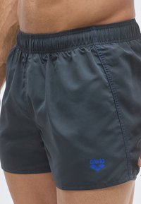 Μαύρο μαγιό σορτς κατασκευασμένο από ελαφρύ υλικό με ελαστική μέση. Διαθέτει μπλε λογότυπα και λεπτομέρειες ραφής στα πλαϊνά.