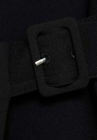 Cintura in tessuto nero con fibbia rettangolare. Il materiale è intrecciato con una finitura testurizzata. La fibbia presenta un perno in metallo argentato.