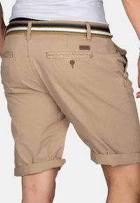 Beige shorts with rolled cuffs and a textured waistband featuring green, blue, and white stripes. Includes two back pockets.