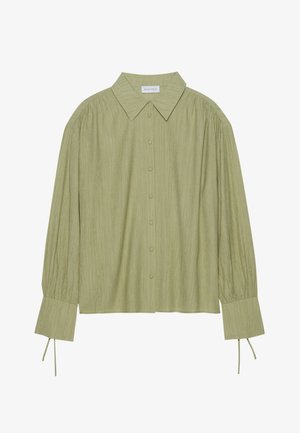 Gai zaļš garo piedurkņu krekls ar pogu aizdari priekšpusē, apkakli, teksturētu audumu un kakla detaļām pie aprocēm. Taisnas apakšmalas dizains.