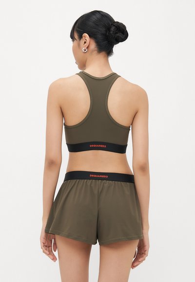 Olive green sports bra with a racerback design and black band featuring "DSQUARED2" in orange. Paired with matching olive shorts.