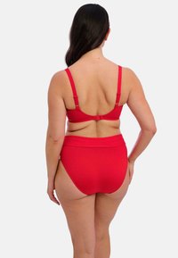 Red two-piece swimsuit with a structured top featuring adjustable straps and a hook closure, paired with high-waisted briefs for coverage.