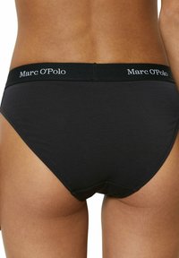 Schwarze Baumwollslips mit einem breiten elastischen Bund, der mit "Marc O'Polo"-Branding versehen ist. Glatte Textur und klassisches Schnittdesign.
