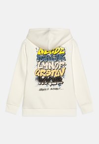 Sweat à capuche crème avec une inscription en lettrage graffiti coloré dans le dos, comprenant des accents bleus, jaunes et noirs. Tissu doux.