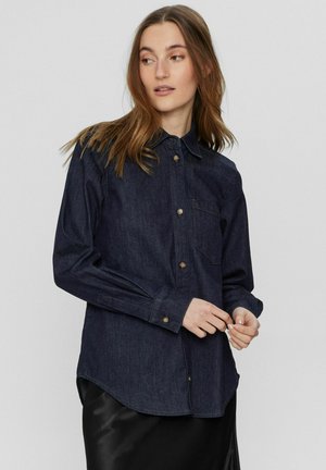 Dunkelblaues Jeanshemd mit Kragen, langen Ärmeln und einer Brusttasche. Verfügt über goldfarbene Knöpfe und einen abgerundeten Saum.