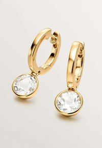 Pendientes de aro de oro con un acabado suave, que presentan un colgante de cristal facetado, claro y redondo. Diseño elegante y minimalista.