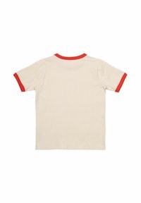 Camiseta de manga corta en color crema con cuellos y terminaciones de mangas rojas. Textura suave, corte casual y sin gráficos ni patrones visibles.