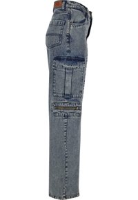 Denim cargo pants in light blue; features large side pockets, a zippered pocket, and a straight leg design. Textured fabric with slight fading.
