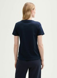 T-shirt bleu marine avec un col rond et des manches courtes. Texture douce, coupe ajustée, design minimaliste, sans motifs ni accents visibles.