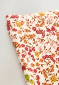 Virágmintás szövet, világos krémszínű alapon rózsaszín, sárga és barna virágokkal, bordázott textúrával, szépen behajtva a saroknál.