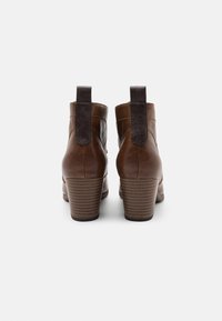 Brune læder ankelstøvler med en stablet hæl, der har en kontrasterende tekstureret panel og trækstropper bagpå for nem påklædning.