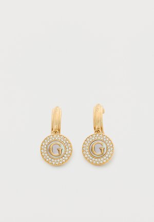 Gold hoop earrings with circular pendants featuring the letter "G" surrounded by small clear rhinestones.