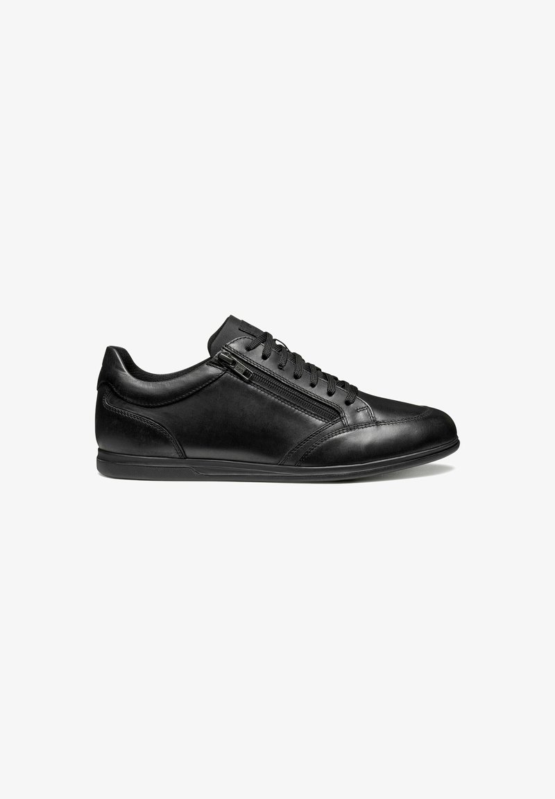 Zapatilla de cuero negro con diseño bajo, puntera redonda, suela de goma plana, cierre de cordones en la parte delantera y cremallera lateral para un acceso fácil.