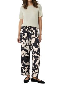 Lichtgroen kortekoope top gecombineerd met navy en crèmekleurige bloemenprint brede broek met een elastische tailleband en trekkoord. Zwarte ballerina's.