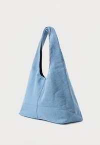 Saco de tecido azul com forma triangular, apresentando uma única alça para o ombro, textura lisa e sem hardware ou padrões visíveis.