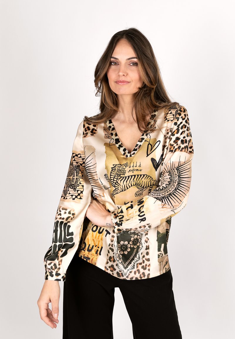 Silk blouse featuring a V-neck and long sleeves, adorned with a mix of animal prints, graphic designs, and bold black text.