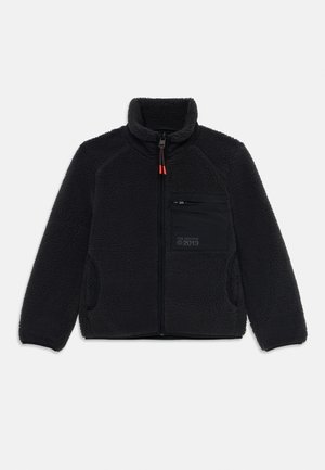 Schwarze Fleecejacke mit hohem Kragen, Frontreißverschluss und Reißverschluss-Brusttasche. Mit kontrastierenden schwarzen Stoffen und orangenen Reißverschlussakzenten.