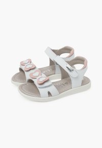 Sandalias de cuero blancas con aplicaciones de mariposas rosas y correa de cierre de gancho y bucle. Plantilla texturizada y suela flexible de goma blanca.