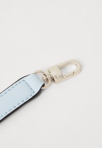 Cinturino in pelle blu cielo con bordo nero, dotato di una chiusura in metallo argentato lucido e di un anello per il fissaggio. Dettagli della superficie testurizzata visibili.