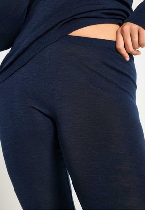 Marinblå leggings tillverkade av ett mjukt, texturerat tyg med hög midja, som har en slät yta och en figurnära passform.