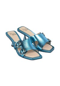 Mules de tacón alto metálico azul con dos acentos de hebilla, abertura en la punta, forma cuadrada y textura suave en las correas y la plantilla.