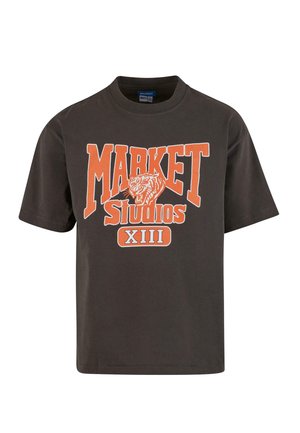 Fekete pamut póló narancsszínű grafikával, amelyen az "MARKET Studios XIII" felirat és egy tigris mintázat látható. Rövid ujjú és kerek nyakú.