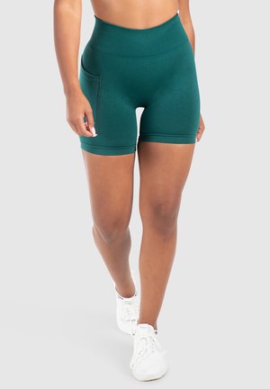 Teal hooggelegen sportshorts met een gladde textuur, voorzien van een zijzak en minimale naaddetailing, gecombineerd met witte sneakers.