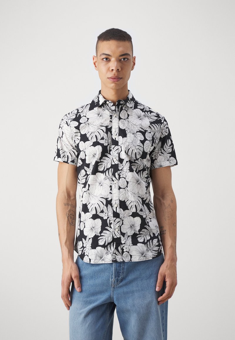 Korte mouwen zwart-wit bloe shirt met hibiscus- en bladvormen, gemaakt van lichte stof, met een button-down kraag.