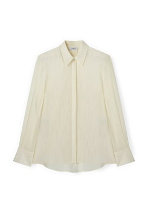 Kremowa bluzka z długim rękawem o subtelnym teksturowanym wzorze, zaostrzonym kołnierzyku, ukrytym zapięciu na guziki oraz szerokich mankietach.