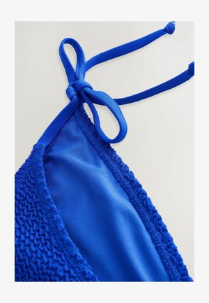 Modré bikiny s hladkým vnútorným materiálom a štruktúrovaným vonkajším okrajom. Na každej strane sa viaže na uzol pre nastaviteľné prispôsobenie.
