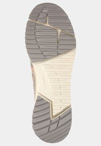 Lekki bieżnik sportowy z szarym wzorem z gumy, z rowkami zapewniającymi przyczepność oraz kremową podeszwą środkową. Widoczne logo marki.