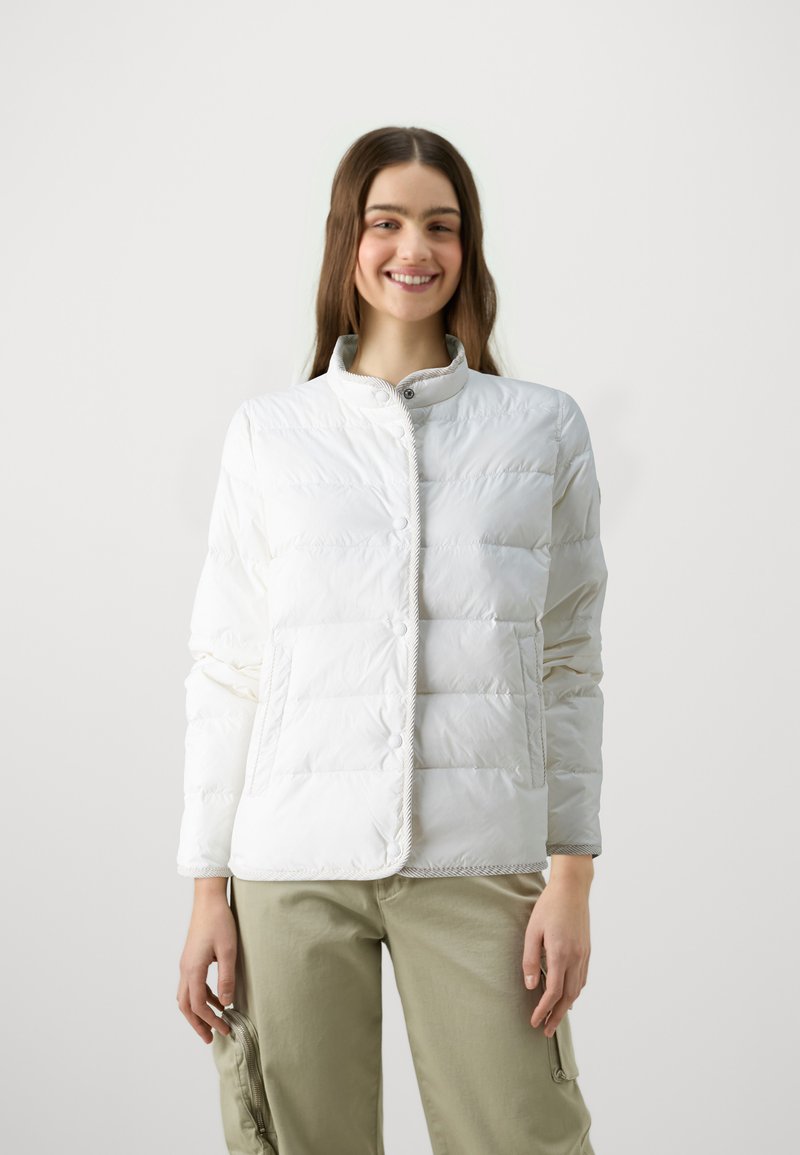 Veste en duvet blanche, légère, avec un col montant, une fermeture à boutons et deux poches avant. Texture lisse, design matelassé et léger éclat.
